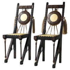 two chairs with tassels and mirrors on them