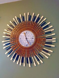 a clock made out of wooden sticks on the wall