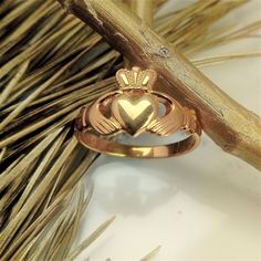 a gold cladder's heart ring sitting on top of a twig