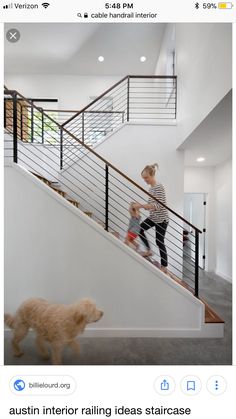 a woman and her dog walking up the stairs in a modern house with white walls