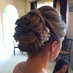 a woman in a pink dress is wearing a hair comb with pearls and beads on it