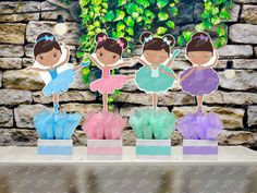 three little ballerinas are standing in front of some flowers