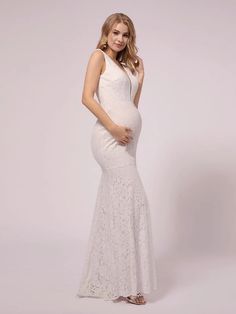 a pregnant woman in a white gown posing for the camera with her hand on her hip