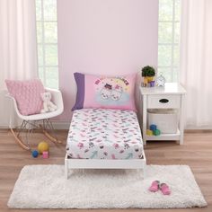 a small child's bedroom with pink walls and white rugs on the floor