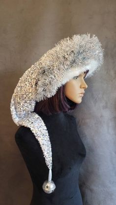 SIZING  XL will fit 25 to 26 inch heads, and the average with silver bell will fit 22 to 24 inch heads. Both of these with the silver bell are an extra long hat at over 3 feet long from the brim to the end of the silver glitter bell. The short hats will all fit 22 to 24 inch heads and are over 20 inches long from the brim to the end of the white glitter bell.    All of these hats are made from a gorgeous white velvet that is encrusted with silver sequins for an over the top elegant look. The hat Elaborate Christmas Hats, Long Hat, Xmas Costumes, Silver Tinsel, Elf Hat, Silver Bells, White Velvet, White Fur, White Glitter