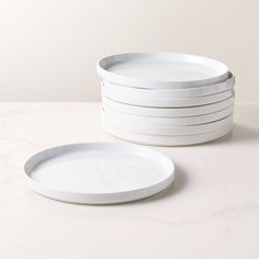 a stack of white plates sitting on top of a table