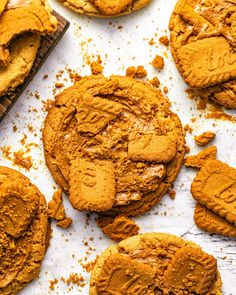 several cookies with peanut butter on top and one cookie broken in half next to it