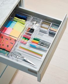 an organized drawer with pens, pencils and scissors