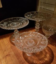 three glass dishes sitting on top of a wooden table