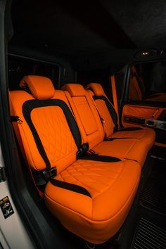 the interior of a vehicle with orange leather seats and black trimmings on it