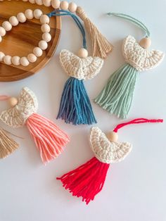 several tassels are arranged on a white surface next to a wooden bead necklace