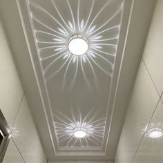 the ceiling in this bathroom is made up of white tiles and has a circular light fixture above it