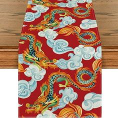 a red and blue table runner with dragon design on the front, along with white clouds in the background