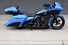 a blue and black motorcycle parked in front of a building