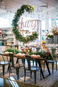 a table with chairs and flowers on it in front of a sign that says cheezy