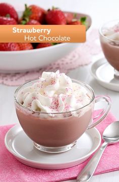 strawberry hot chocolate with whipped cream and sprinkles in a glass bowl on a plate