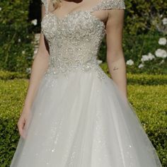 a woman in a white wedding dress standing outside