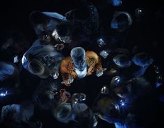 a group of people standing around each other in the dark with their cell phones on