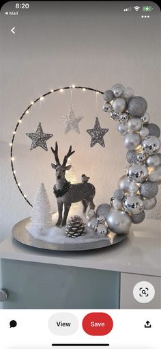 a white christmas decoration with silver ornaments and reindeer figurines on top of it