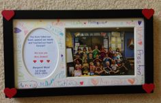 a group of children are posing in front of a photo frame with writing on it