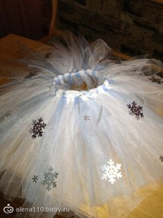 a tutu with snowflakes on it sitting on top of a wooden table