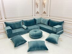 a living room with blue couches and pillows on the floor in front of white walls