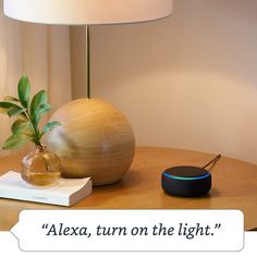 a table with a lamp and an amazon echo device on it that says,'alexa, turn on the light '