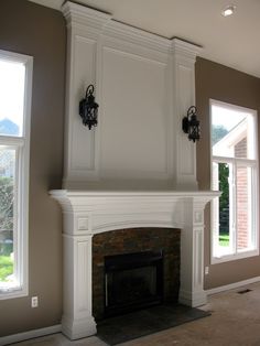 an empty living room with a fireplace and two windows in the wall, along with carpeted flooring