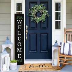 a blue front door with a welcome sign and rocking chair on the porch next to it