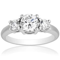 When you see this 1.50 carat total weight diamond ring you will immediately be enchanted by its timeless elegance and beauty. Set in finely crafted 18 karat white gold, this diamond ring features a .70 carat center diamond and is complimented by two .40 carat round shaped diamonds on each side. We know the quality of your diamond ring is important and therefore, it is authenticated and accompanied by an IGI certificate. Diamond Three Stone Ring, Stone Diamond Ring, Three Stone Diamond Ring, Three Stone Diamond, Three Stone Rings, Gold Engagement Rings, Three Stone, Jewelry Store, Stone Rings