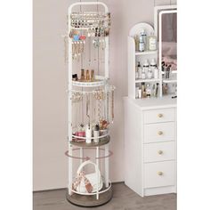 a white jewelry rack sitting next to a dresser