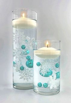 two glass vases filled with candles and snowflakes