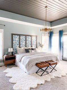 a bedroom with a large bed and white rugs on the floor in front of windows