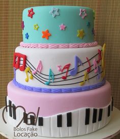 a multi layer cake with musical notes and stars on it's top is decorated in pastel colors