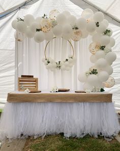 a table topped with white balloons and flowers