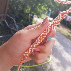 a hand holding an orange and white rope