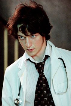 a young man wearing a white coat and tie with a stethoscope on his neck