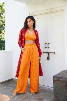 Induce a sense of freshness to your wardrobe with our Bandhej two piece co-ord set with leheriya jacket.Made in soft cotton and modal satin.Top features a V- neckline,bust cups and tie up detail at the back.Pants feature an elasticated back waist, side zipper and side seam pockets.Jacket features a ribbed collar along the length, batwing sleeves and ribbed cuff.Highlighted with a back tie up detail and side seam pockets.Styling Tip- Accessories the set with some statement earrings for some added Bandhani Coord Set, Coord Set With Jacket, Matching Set With Straight Pants, Fitted Cotton Sets With Straight Pants, Summer Cotton Palazzo Set With Straight Pants, Festive Cotton Set With Straight Pants, Festive Cotton Sets With Back Tassel Tie-up, Festive Cotton Loungewear Sets, Cotton Palazzo Set With Straight Pants