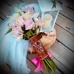 a bouquet of flowers sitting on top of a wooden table next to a candle holder