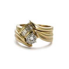 a yellow gold ring with two diamonds on the top and bottom, set against a white background