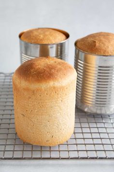 two tins sitting on top of a cooling rack with muffins in them