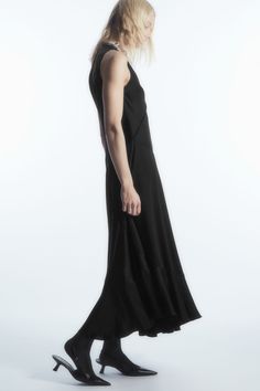 The COS womenswear team looked to classic lingerie when designing this modern midi dress. Crafted from fluid TENCEL™ Lyocell-blend satin, it's shaped in a floaty silhouette that's enhanced by the asymmetric hemline, contrasting panels and bodice-defining seams. Frame the V-neckline with a statement necklace. Relaxed fitSleevelessTENCEL™ is a trademark of Lenzing AG. TENCEL™ Lyocell is made from renewable wood sources, using a process that recycles 99% of all chemicals and water 66% Viscose, 34% Modern Midi Dress With Flattering Silhouette, Spring Bias Cut Midi Dress In Viscose, Fitted Viscose Midi Dress With Bias Cut, Evening Midi Dress With Asymmetrical Hem And Bias Cut, Fitted Bias Cut Viscose Midi Dress, Viscose Midi Dress With Bias Cut For Daywear, Fitted Modal Satin Maxi Dress For Spring, Fitted Modal Satin Dress For Daywear, Sleek Midi-length Dresses With Minimal Stretch