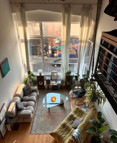 an overhead view of a living room with couches, coffee table and bookshelves