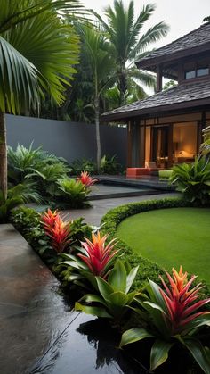 a lush green yard with red and yellow flowers in the center, surrounded by palm trees