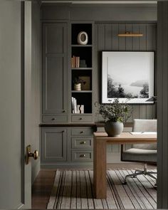 an office with gray walls and wooden floors, built - in bookshelves and desk