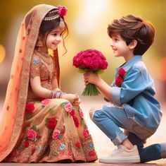 two young children are sitting on the ground and one is holding flowers while the other holds roses