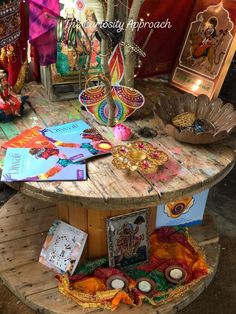 a wooden table topped with lots of cards and candles next to other items on top of it