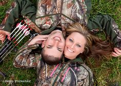 a man and woman laying on the ground with archery bows in their hands next to each other