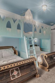 two beds in a room with blue walls and snow themed decorations on the ceiling, while another bed has been made into a sleigham