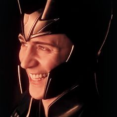 a close up of a person wearing a helmet and looking at the camera with a smile on his face